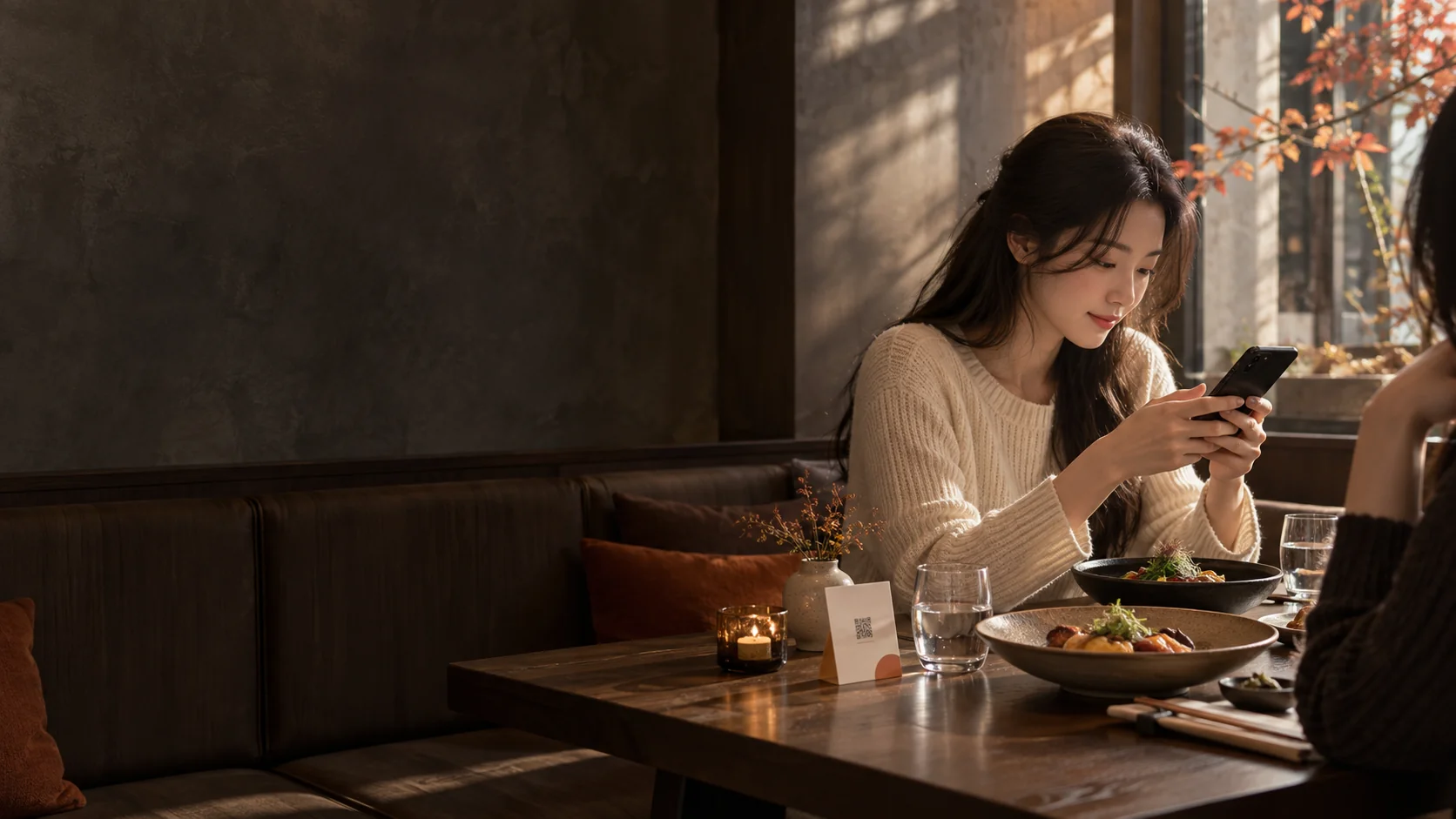 따뜻한 분위기의 식당에서 휴대폰으로 메뉴를 살펴보는 손님